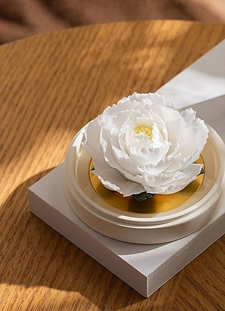 A white porcelain peony on a gold-rimmed base